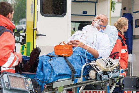 person being wheeled into an ambulance with a medpac bag